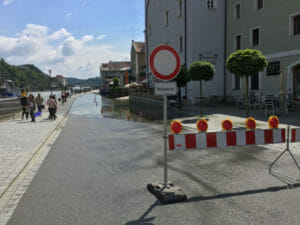 Hochwasser Dreiflüssestadt Passau am Donauradweg mit Schild und Wasser