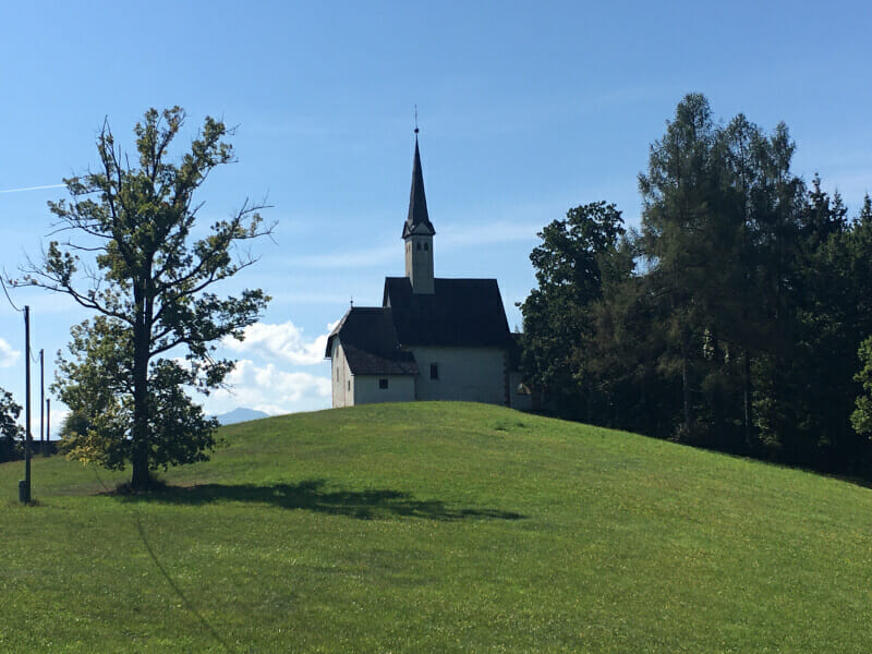 Kirche bei St. Lorenzen am Drauradweg. Saftige Wiese.