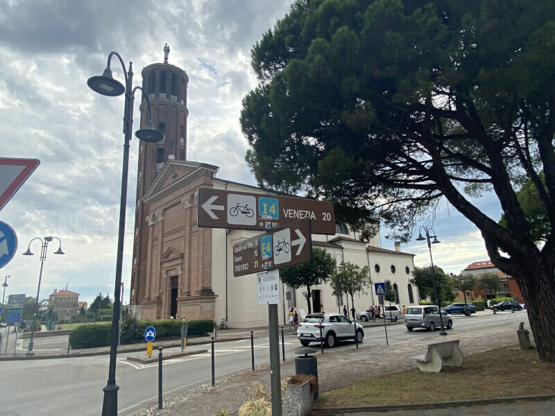 Quarto d'Altino, Innenstadt mit Kirche und Radwegweiser. Am Via Claudia Augusta Radweg.