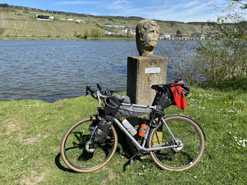 Römerfigur in Riol mit Gravelbike davor - Moselradweg